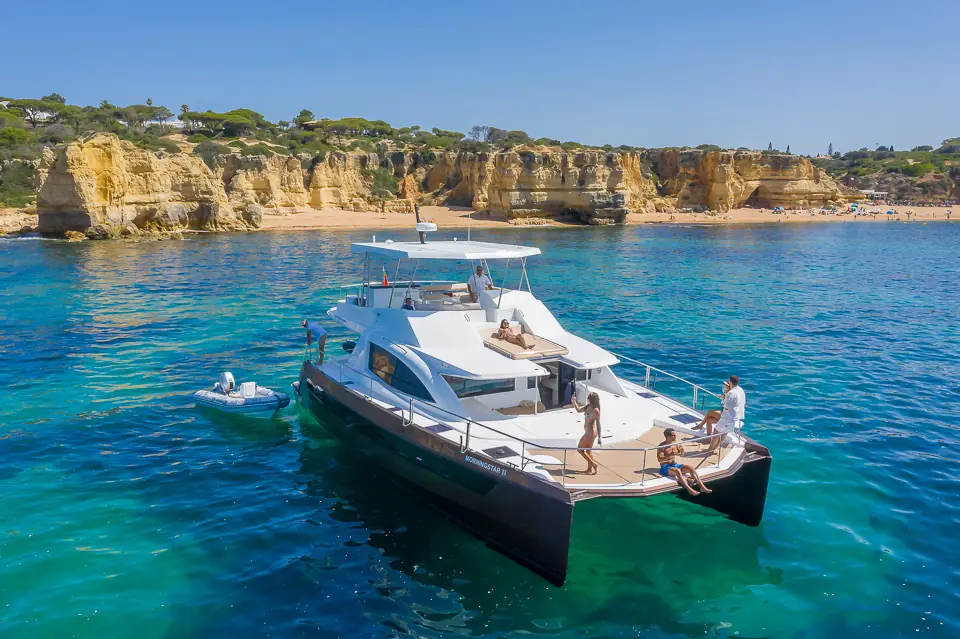 Morningstar catamaran anchored below the Algarve cliffs